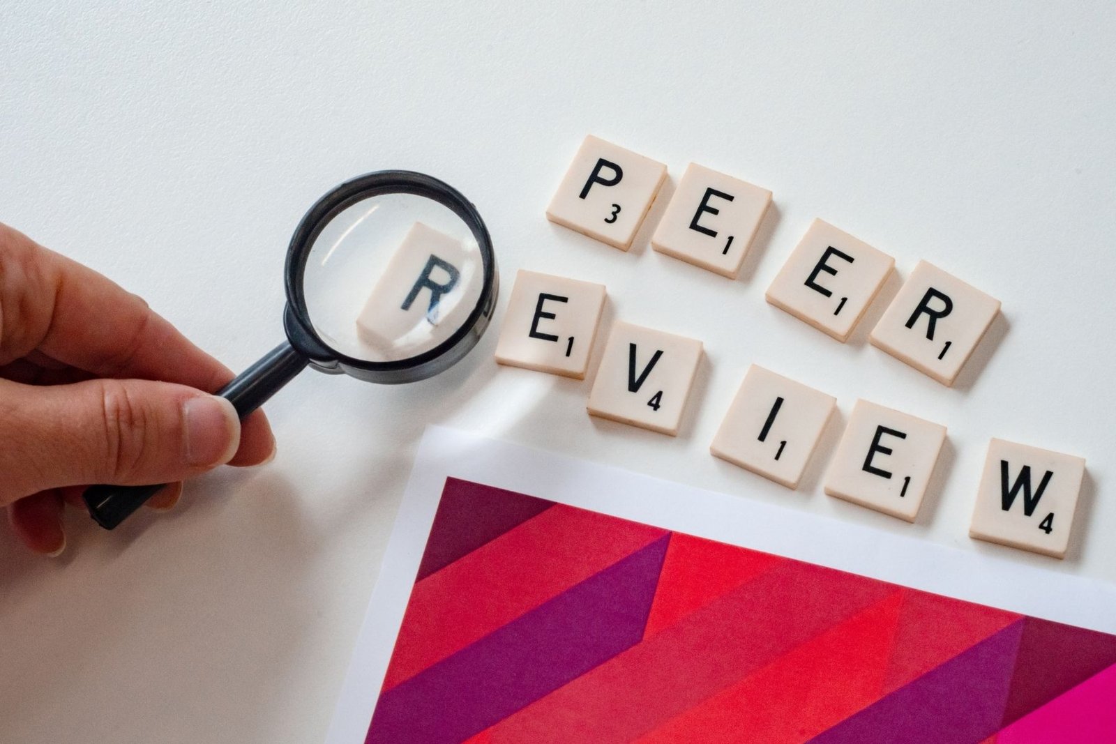 Editor jurnal ilmiah meninjau naskah penelitian menggunakan laptop dengan catatan koreksi di layar